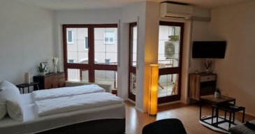 Hotelreinigung - Glim Reinigungsservice Hotelzimmer mit frischen Bettwäsche – Ein ordentliches Hotelzimmer mit einem perfekt gemachten Bett, dekorativen Kissen und einem einladenden Ambiente, das zur Entspannung einlädt.